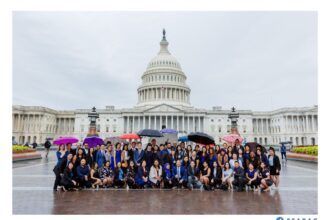 A group of leaders posing at the US Capitol in rainy conditions