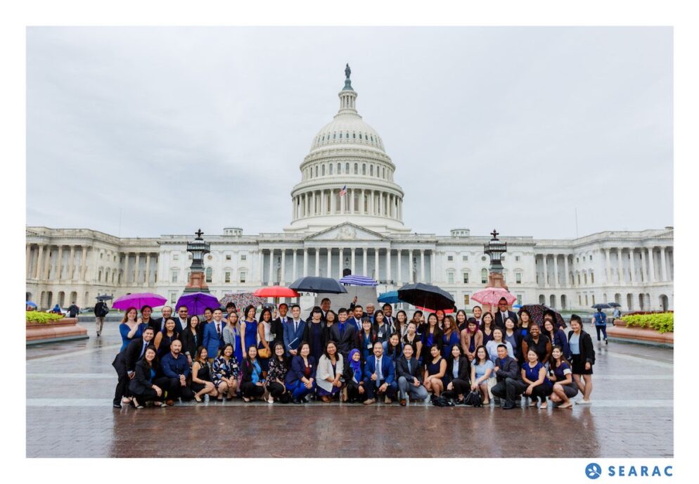 A group of leaders posing at the US Capitol in rainy conditions