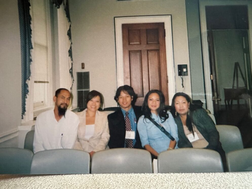 Five individuals sit in a row of chairs