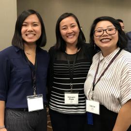 Three people at a conference smiling together