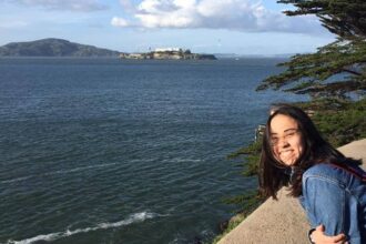 A person smiling by the water