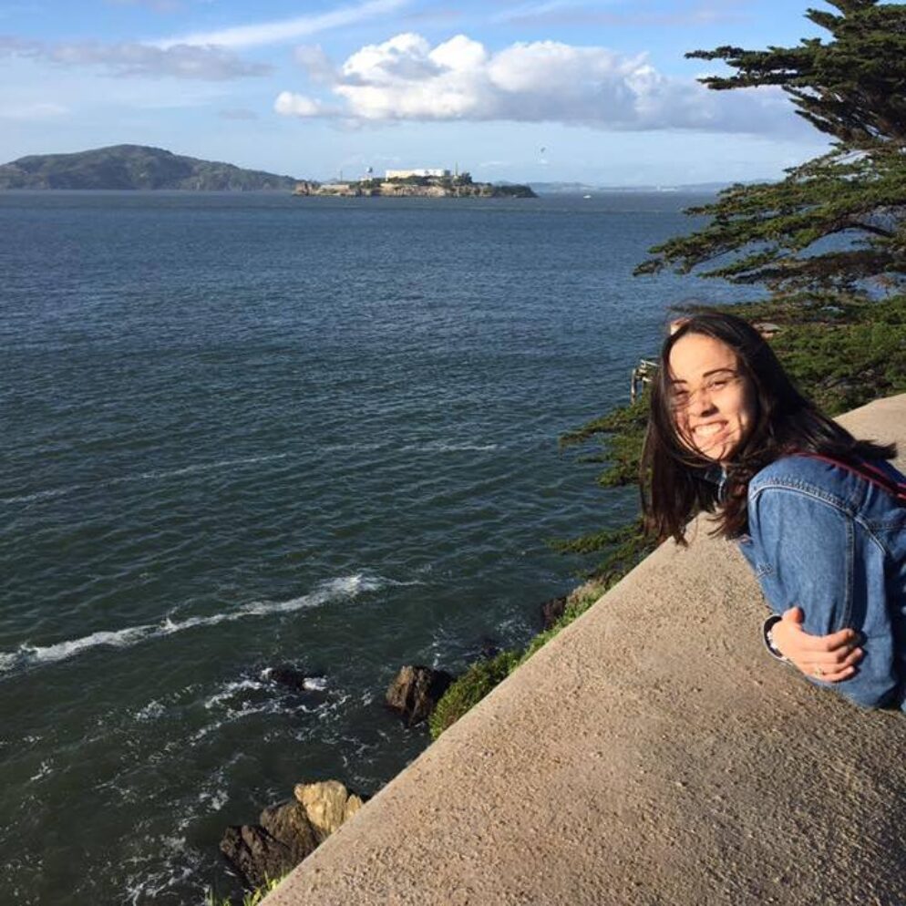 A person smiling by the water