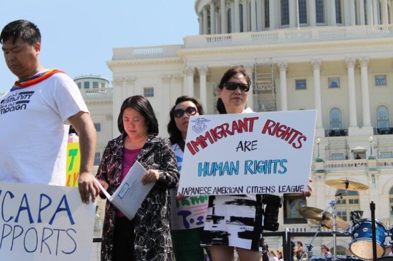 People holding signs in support of immigrant rights.