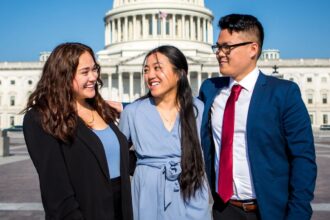 Alexis and fellow interns smiling at each other in front of the Capitol Building