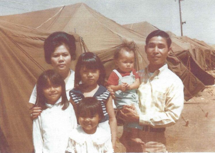 A brown tinted photo of a mother and father with their four children.