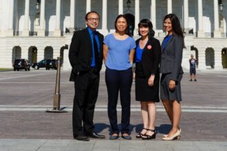 Four individuals including blog author Cheryl Yin stand in front of a building