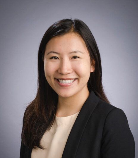 Mandy smiling with a grayish backdrop.