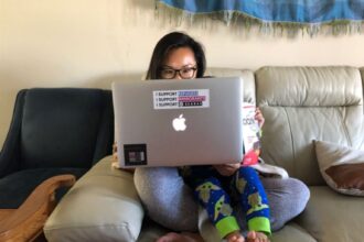 Elaine sitting with her son on a couch.