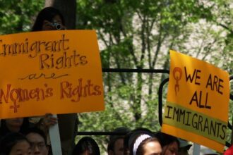 Yellow signs advocating with immigrant and women's rights.