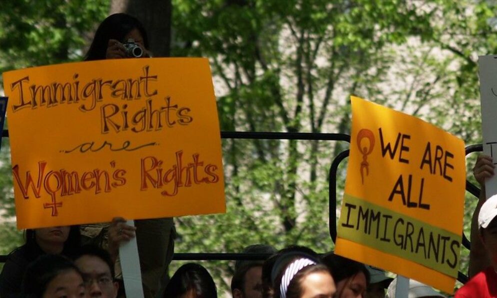 Yellow signs advocating with immigrant and women's rights.