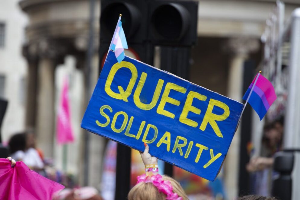 A hand holding a blue sign with yellow text