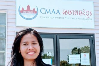 Leakhena standing in front of the Cambodian Mutton Assistance Association's office.