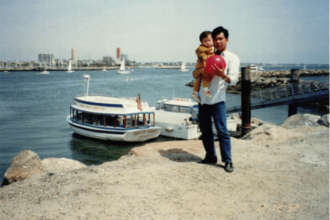 Baby Mandy being held by her father at a bay.