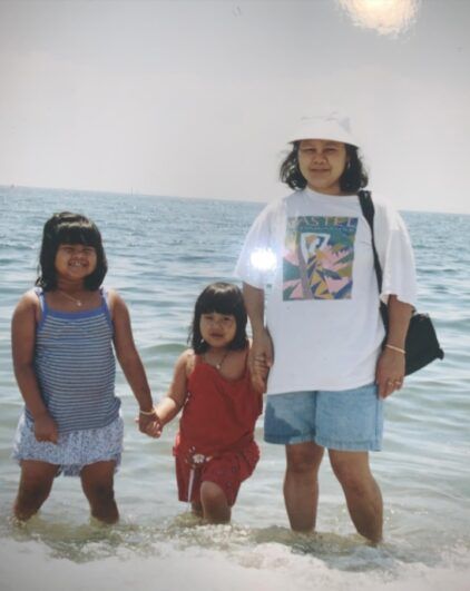 Nary as a young child with her sister and mother at a beach.