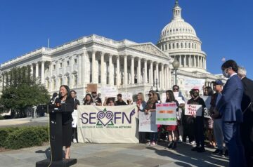 Group of people gather behind a speaker at the SEADRA press conference