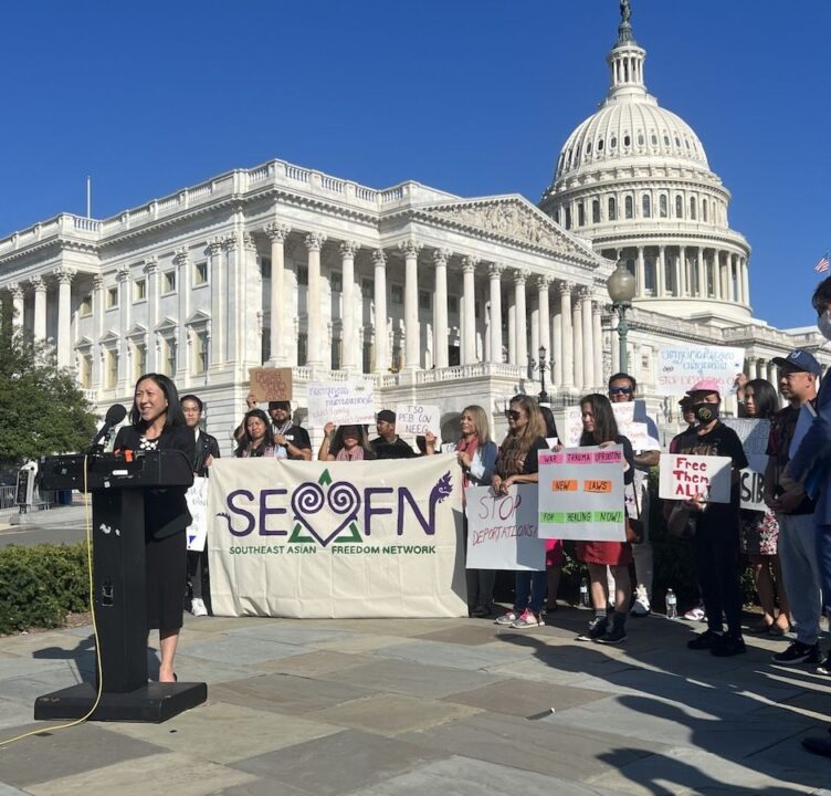 Group of people gather behind a speaker at the SEADRA press conference