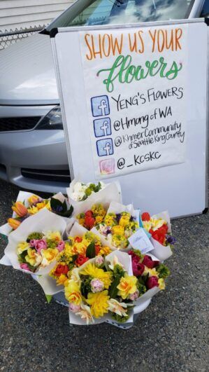 A group of bouquets in front of a sign with social media handles.