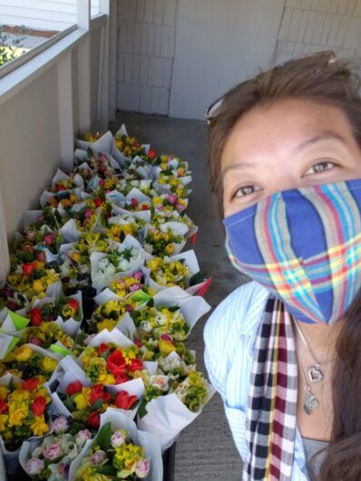 Stephanie Ung taking a selfie in front of a group of bouquet.