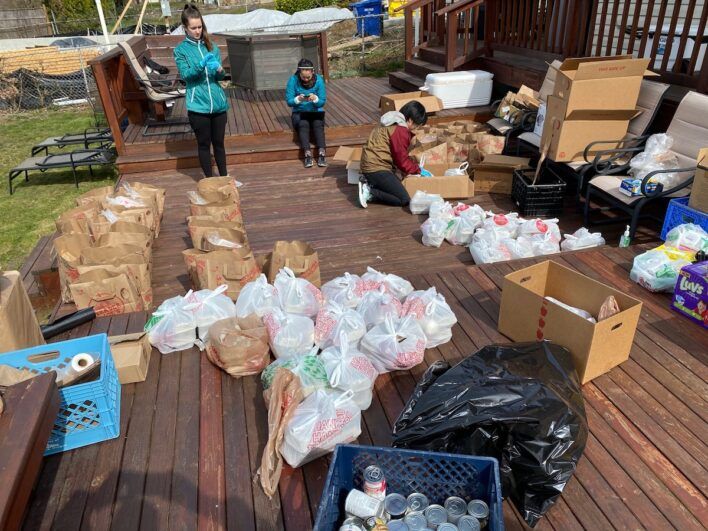 Staffs stocking goods in plastic and paper bags.