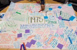 Post-its and handwritten messages on a posterboard labeled with the year 1975