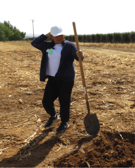 A woman holding a shovel.