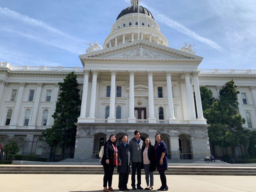 An image of 5 people standing in front of the state capital building