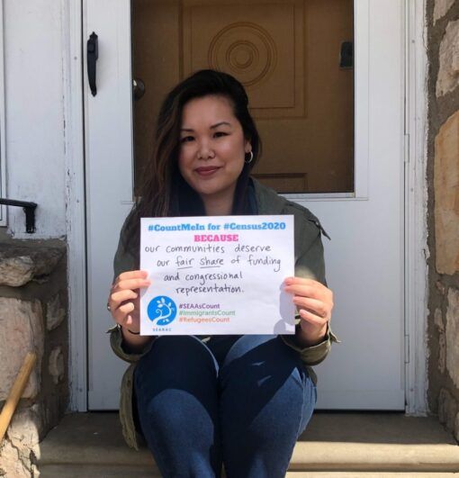 A woman holding a sign about why she should be counted for the Census 