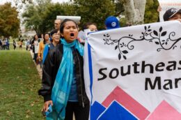 Person holds a banner and stands at the front of a march