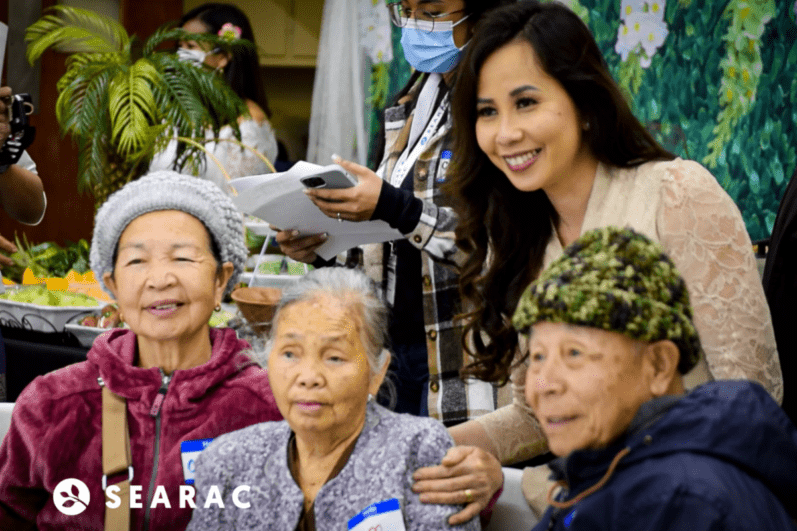 A young woman smiling with elders.