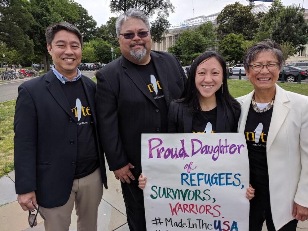 Quyen holding a poster showing her proud identity as a daughter of refugees.