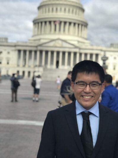 A man smiling at Capitol Hill.