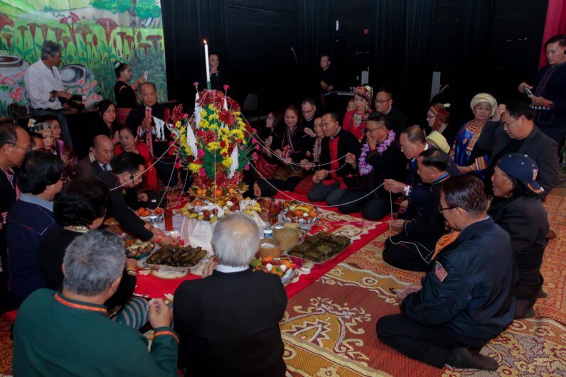 Khmus gathering around a flowery decoration.