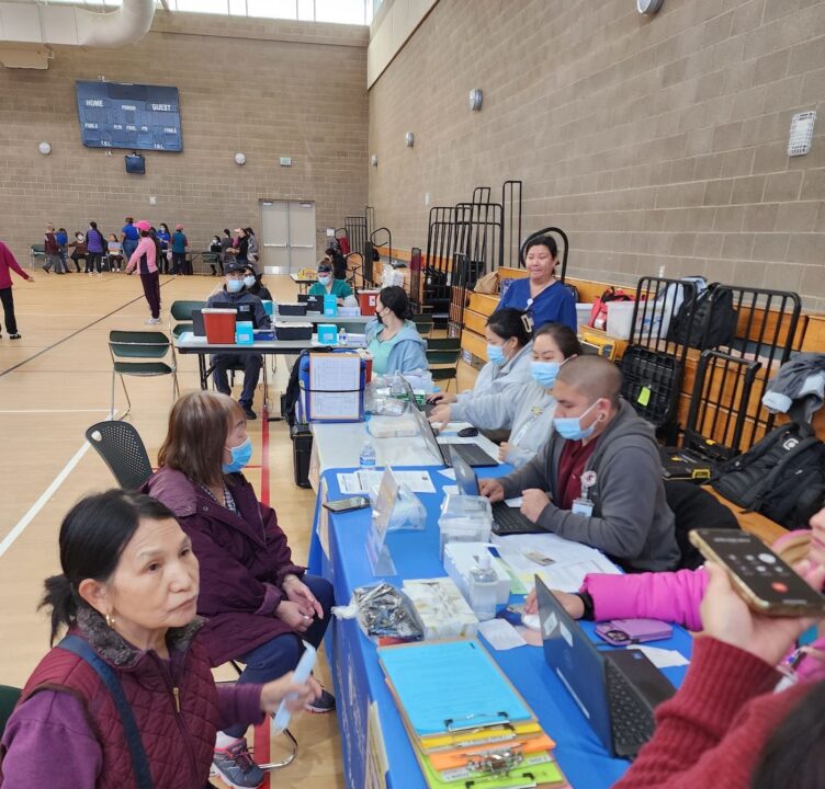 People sit at a booth at a community event