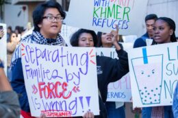 People hold up anti-deportation signs