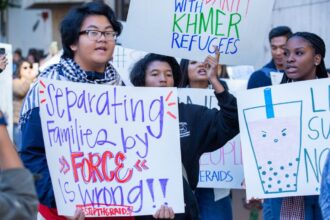 People hold up anti-deportation signs