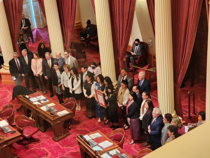 A group of people in a room with red carpets.