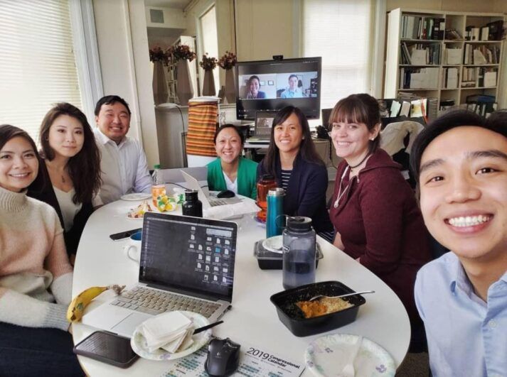 A selfie of group of coworkers having lunch together, they are smiling together