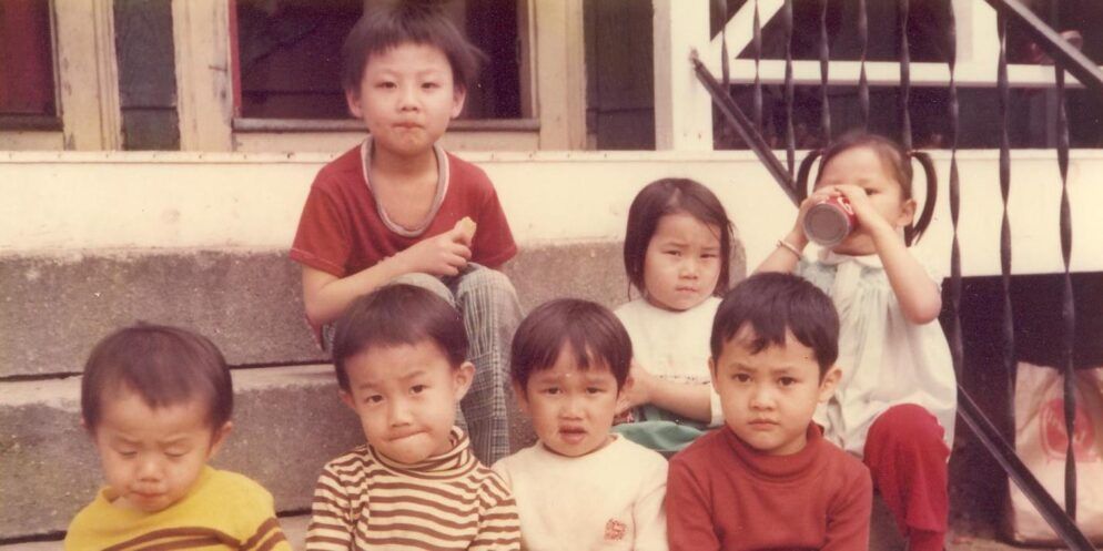 An older photograph shows children sitting atop stairs