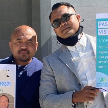 Chanthon and Tith hold up signs against deportation