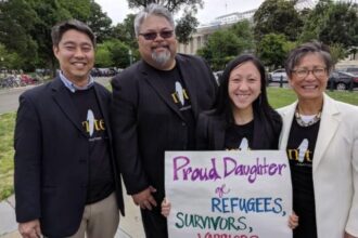 Quyen holding a sign showing her proudness of her identities.