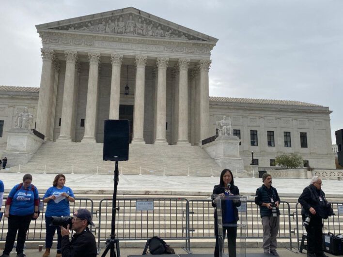 Quyền speaks in front of the Supreme Court.