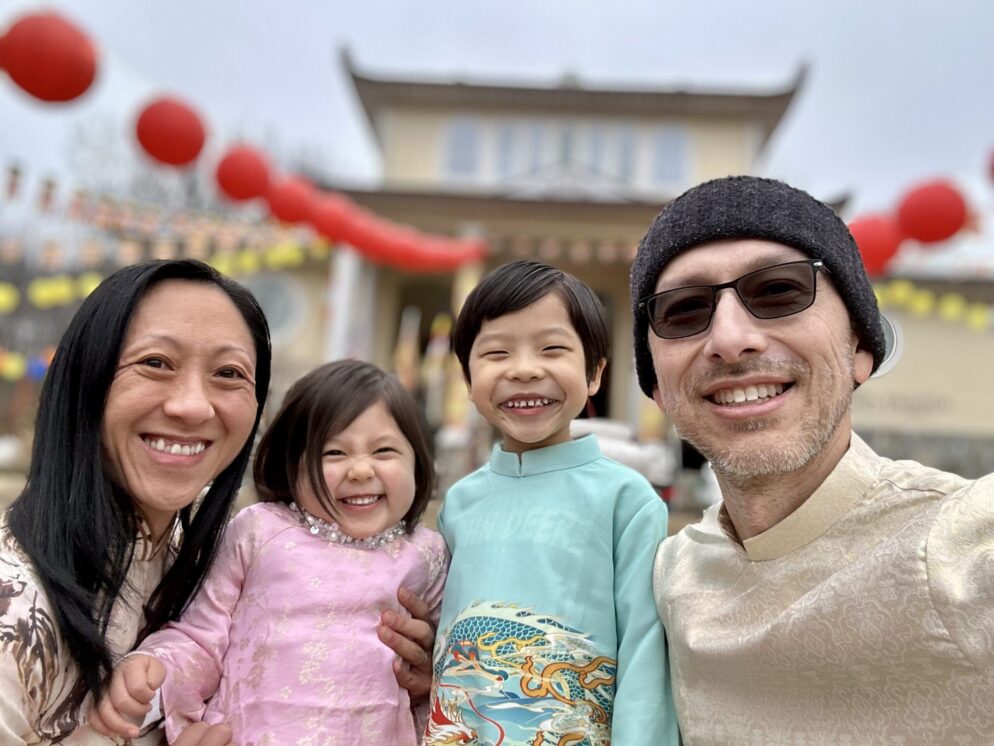 Family poses in front of temple and red lanterns