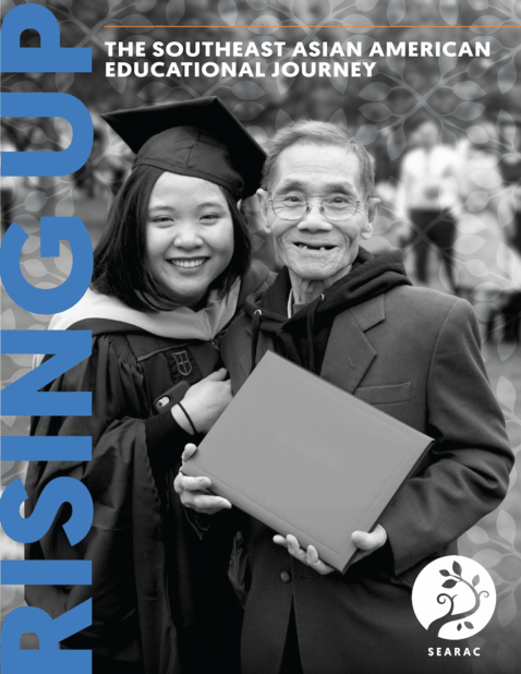 A graduate poses in celebration next to a man holding a diploma