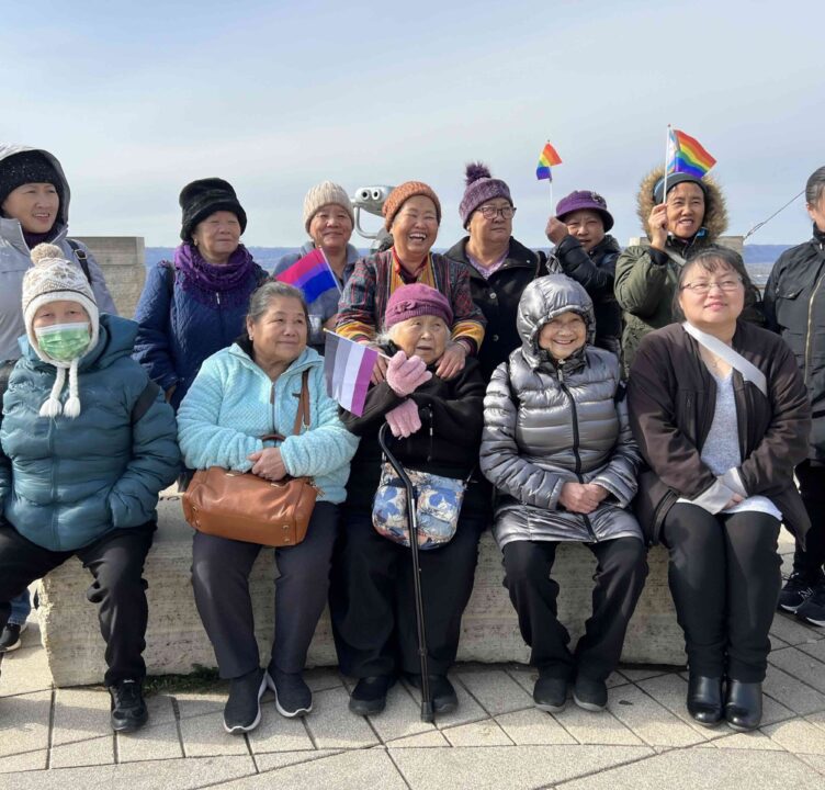group of seniors wearing coats and waving flags