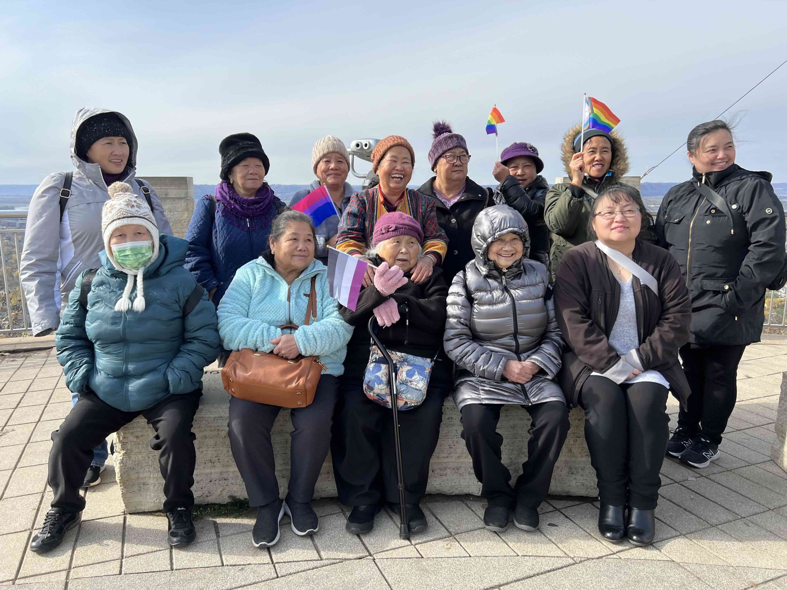 group of seniors wearing coats and waving flags
